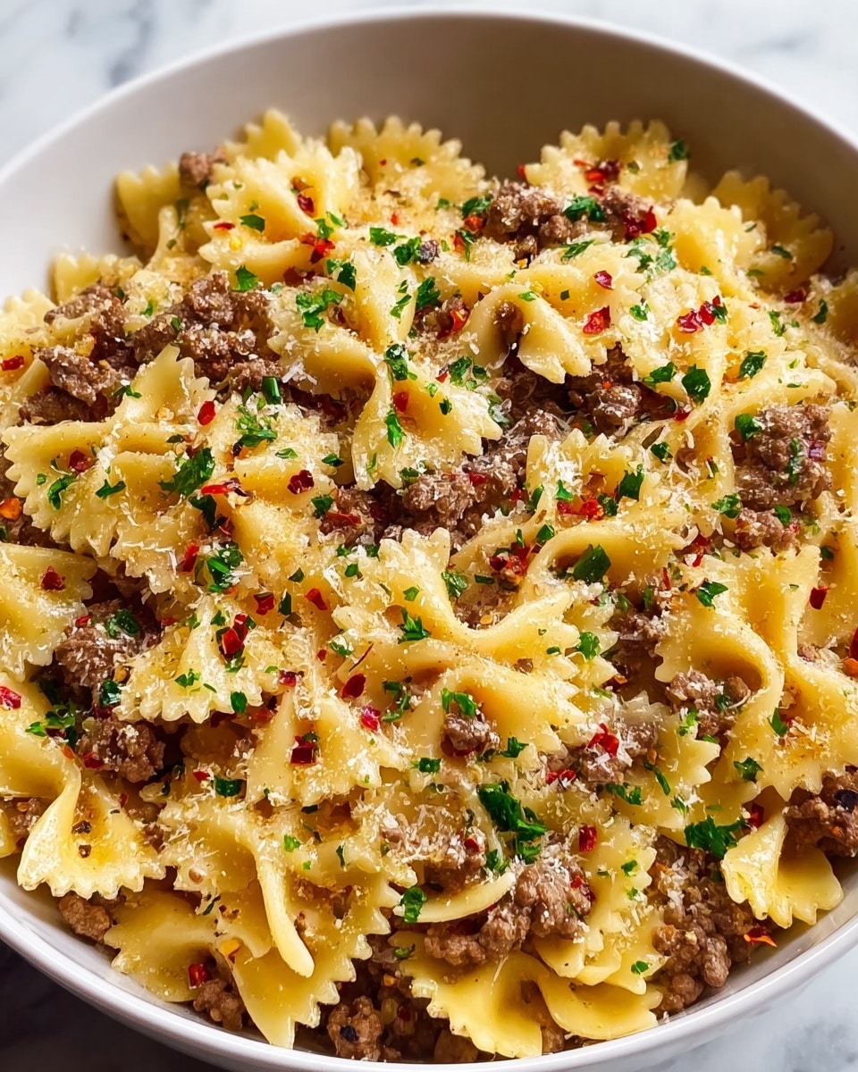 A white bowl is filled with farfalle pasta mixed evenly with ground beef pieces; the pasta is a light yellow color and firm in texture with small ridges on the edges. The top layer is lightly sprinkled with grated cheese, finely chopped green parsley, and small red chili flakes, adding pops of color. The dish has a slightly oily sheen, giving it a warm, freshly cooked look, all set on a white marbled surface. photo taken with an iphone --ar 4:5 --v 7