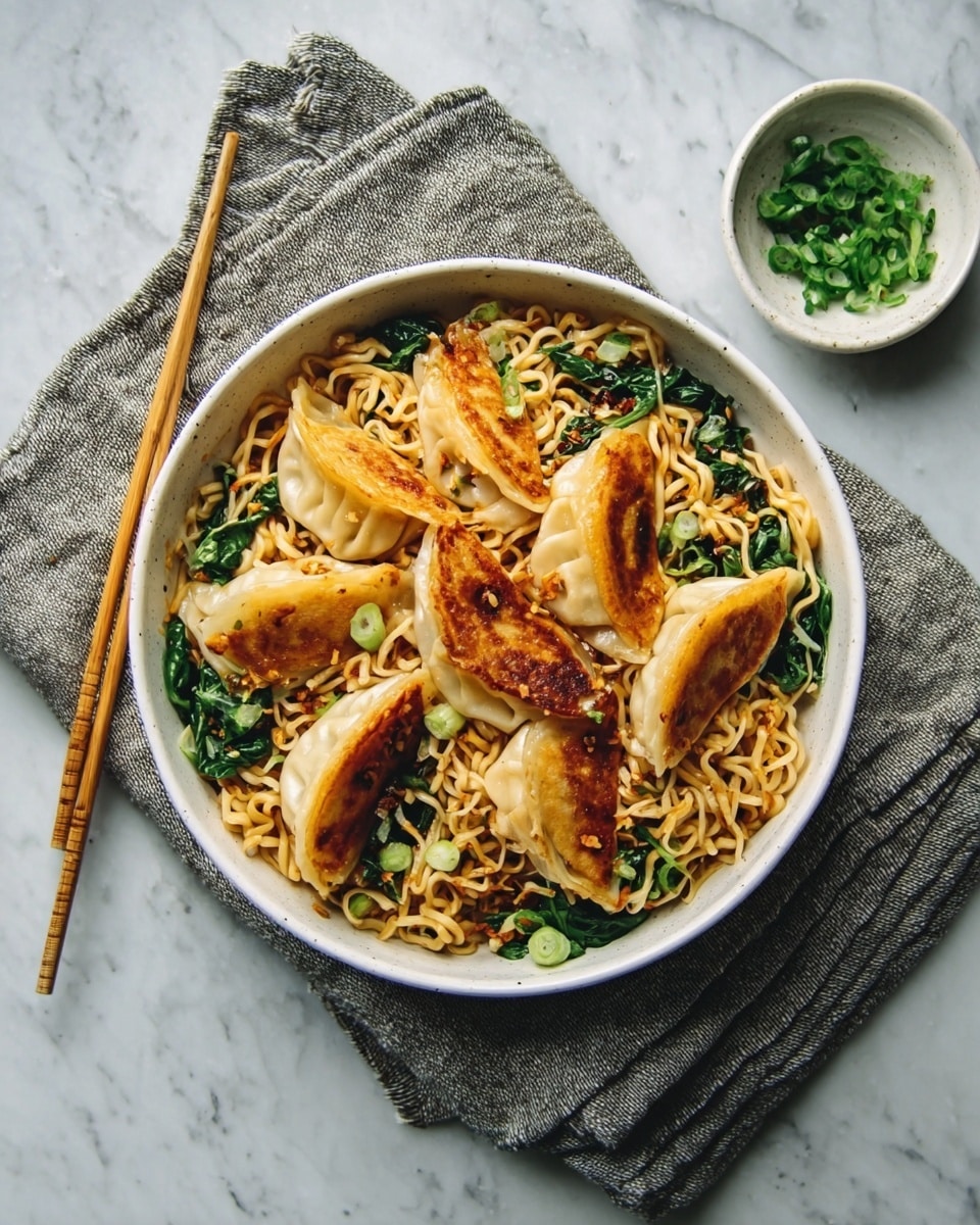 The image shows a white round bowl filled with stir-fried noodles layered at the bottom, with a light golden texture and some visible seasoning. On top of the noodles are green leafy vegetables mixed among the noodles, adding a fresh and vibrant touch. Arranged over the vegetables and noodles are several pan-fried dumplings with a golden-brown crispy side facing up, creating a contrast in texture and color. To the left of the bowl, a pair of wooden chopsticks rest sideways. To the right, a small white bowl contains finely chopped green herbs. The whole setup is placed on a white marbled surface with a grey cloth napkin underneath the bowl. Photo taken with an iphone --ar 4:5 --v 7
