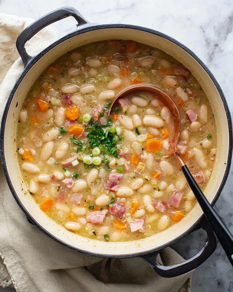A deep white cooking pot filled with thick stew containing white beans, orange carrot pieces, and small pink cubes of ham mixed throughout. The broth looks creamy and slightly chunky, with green chopped herbs and slices of green onion scattered on top in the center. A copper ladle rests inside the pot on the right side, partly submerged, while a black spoon handle extends out from the left side. The pot sits on a white marbled surface with a light beige cloth partially underneath. Photo taken with an iphone --ar 4:5 --v 7