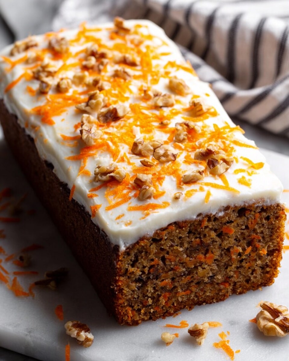 A rectangular carrot cake with one thick brown layer showing a moist, textured crumb filled with carrot bits and small nut pieces, topped with a smooth, thick layer of white cream cheese frosting. The frosting is sprinkled with bright orange shredded carrot and small chopped walnut pieces scattered across the top and around the base. The cake sits on a white marbled surface with a striped cloth in the background. Photo taken with an iphone --ar 4:5 --v 7