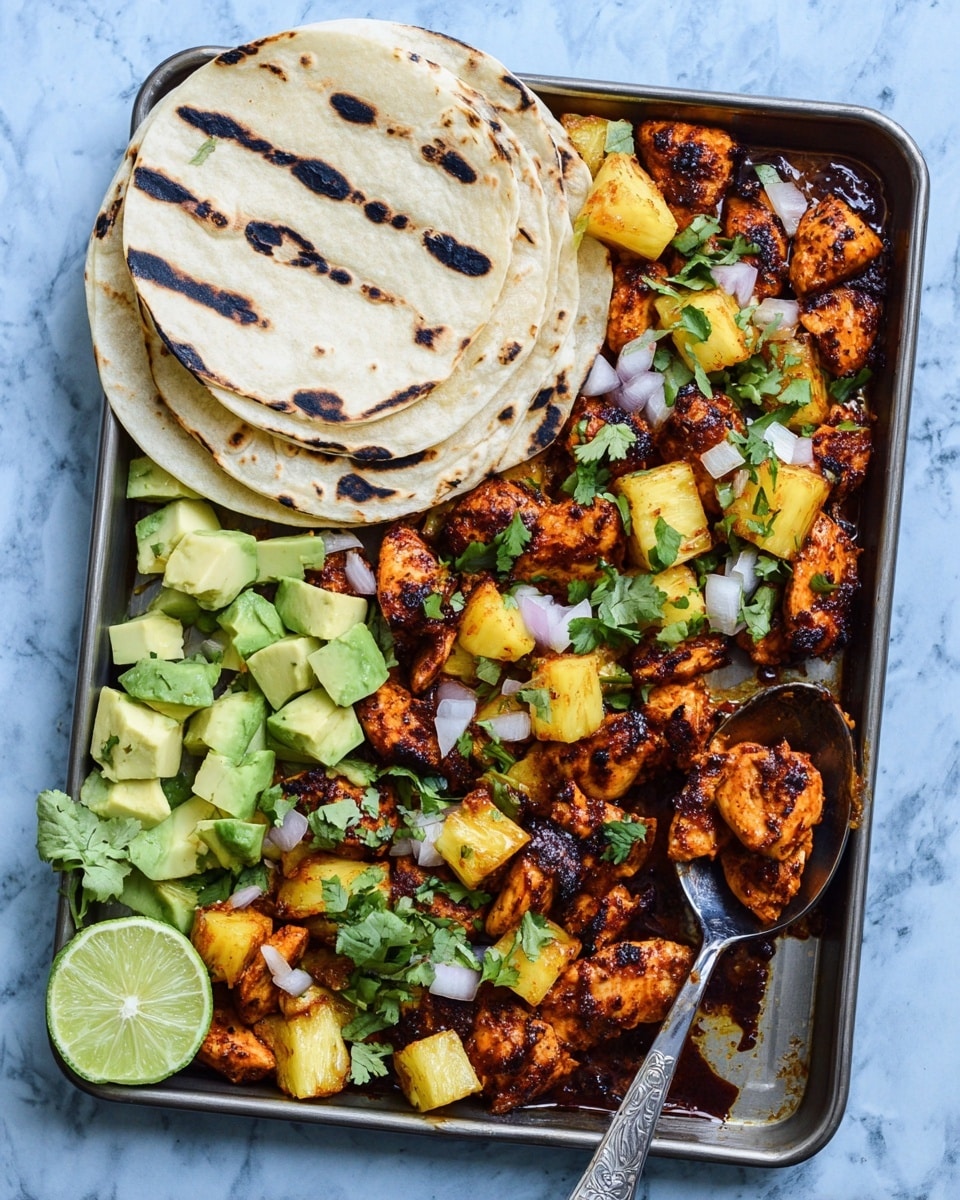 The image shows a metal tray filled with grilled chicken pieces that are dark orange with some charred black spots, mixed with bright yellow pineapple chunks, topped with small white onion pieces and green cilantro leaves. On the left side of the tray, there are three stacked white corn tortillas with light brown grilled marks, beside a lime cut in half, showing bright green and light yellow inside. At the bottom left portion of the tray, there are chunks of light green avocado. A silver spoon rests on the right side of the tray, holding some grilled chicken. The tray is placed on a light blue surface, replaced here with a white marbled texture. photo taken with an iphone --ar 4:5 --v 7