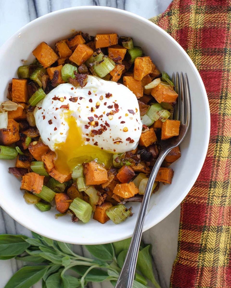 A white bowl filled with a mix of cooked cubed sweet potatoes, green celery pieces, and browned onions, all showing a slight char and rich orange, green, and brown colors. On top of this vegetable base sits a white poached egg with a soft, runny yolk dripping slightly out after being cut, sprinkled with red chili flakes. A metal fork rests inside the bowl on the right side, with a folded checkered cloth in red, yellow, and black pattern placed beside the bowl on a white marbled surface, along with some fresh green herb leaves nearby. photo taken with an iphone --ar 4:5 --v 7