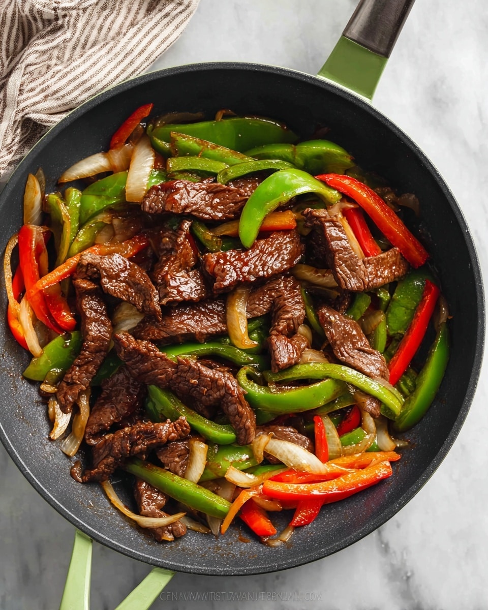 A green-handled black pan sits on a white marbled surface, filled with stir-fried beef strips on top, showing a glossy dark brown color and juicy texture. Below the beef, there is a layer of cooked vegetables including sliced red and green bell peppers and light brown onions; the vegetables look tender and slightly crispy with bright, vivid colors. The pan handle points to the upper right, and a soft striped cloth is seen partially in the top left corner. The overall scene looks fresh and vibrant. photo taken with an iphone --ar 4:5 --v 7